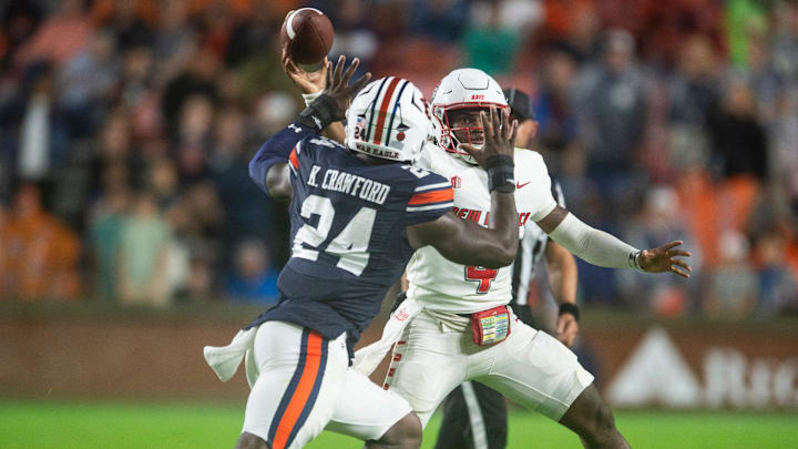 New Mexico Lobos quarterback Devon Dampier (4) throws the ball under pressure from Auburn Tigers defensive lineman Keyron Crawford (24) as Auburn Tigers take on New Mexico Lobos at Jordan-Hare Stadium in Auburn, Ala., on Saturday, Sept. 14, 2024.