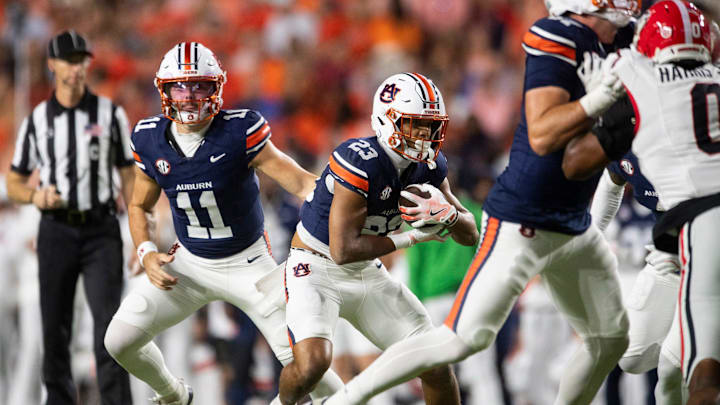 Auburn Tigers quarterback Jackson Arnold (11) hands the ball off to running back Jeremiah Cobb (23) as Auburn Tigers take on Georgia Bulldogs at Jordan-Hare Stadium in Auburn, Ala. on Saturday, Oct. 11, 2025. Georgia Bulldogs defeated Auburn Tigers 20-10.
