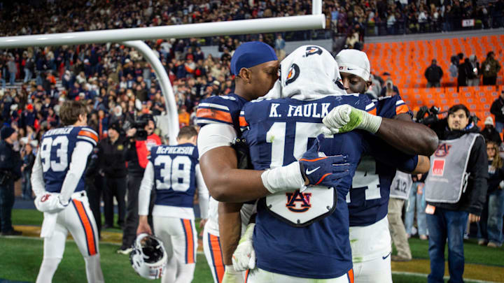 Auburn Tigers defensive end Keldric Faulk (15) is comforted by Favour Ebuka Edwin (70) Keyron Crawford (24) as Auburn Tigers take on Alabama Crimson Tide in the Iron Bowl at Jordan-Hare Stadium in Auburn, Ala. on Saturday, Nov. 29, 2025. Alabama Crimson Tide defeated Auburn Tigers 27-20. Auburn Tigers defensive end Keldric Faulk (15) is comforted by Favour Ebuka Edwin (70) Keyron Crawford (24) as Auburn Tigers take on Alabama Crimson Tide in the Iron Bowl at Jordan-Hare Stadium in Auburn, Ala. on Saturday, Nov. 29, 2025. Alabama Crimson Tide defeated Auburn Tigers 27-20.