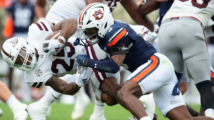 Mississippi State Bulldogs running back Jeffery Pittman (25) is tackled by Auburn Tigers defensive back Keionte Scott (0) as Auburn Tigers take on Mississippi State Bulldogs at Jordan-Hare Stadium in Auburn, Ala., on Saturday, Oct. 28, 2023. Auburn Tigers lead Mississippi State Bulldogs 24-3 at halftime.