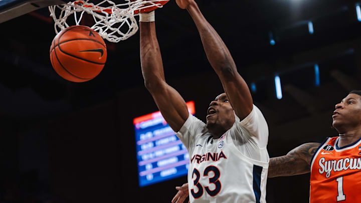 Feb 7, 2026; Charlottesville, Virginia, USA; Virginia Cavaliers center Ugonna Onyenso (33) dunks the ball while Syracuse Orange forward Donnie Freeman (1) defends during the second half at John Paul Jones Arena. Mandatory Credit: Emily Faith Morgan-Imagn Images