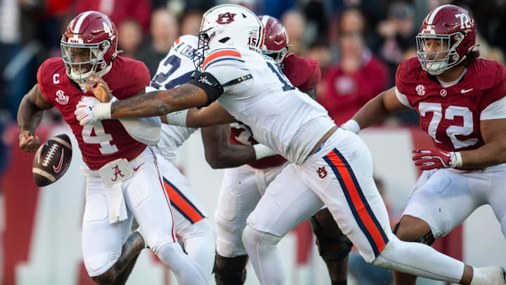 Alabama Crimson Tide quarterback Jalen Milroe (4) fumbles the ball while pressured by Auburn Tigers defensive lineman Keldric Faulk (15) as Auburn Tigers take on Alabama Crimson Tide at Bryant-Denny Stadium in Tuscaloosa, Ala., on Saturday, Nov. 30, 2024. Alabama Crimson Tide leads Auburn Tigers 14-6 at halftime.