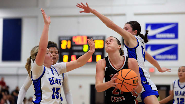 Tocoi Creek's Audrey Beyer (21) splits the defense of Bartram Trail's Alana Larson (15) and Alyssa Donohue (24) during the second quarter of the District 3-6A girls basketball final Friday, Feb. 7, 2025 at Bartram Trail High School in St. Johns, Fla. The Tocoi Creek Toros defeated the Bartram Trail Bears 52-37.