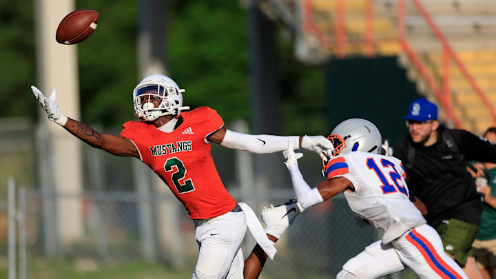 Mandarin's Jaime Ffrench (2) makes a one-handed touchdown reception against Bolles' Santana Starks (12) during the first quarter of a high school football matchup Thursday, May 23, 2024 at Mandarin High School in Jacksonville, Fla. Mandarin defeated Bolles 35-14.