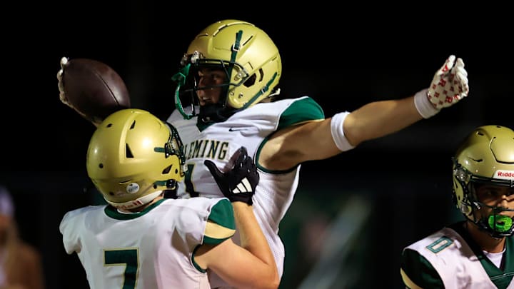 Fleming Island's Parker Sirdevan (7) lifts Sebastian Cruz (1) after Cruz’s touchdown score during the third quarter of a high school football matchup at Fleming Island High School, Friday, Oct. 24, 2025, in Fleming Island, Fla. The Fleming Island Golden Eagles defeated the Middleburg Broncos 21-10.