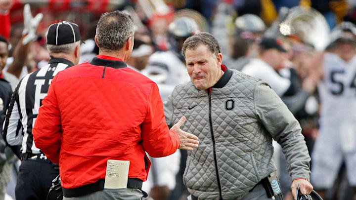 Ohio State Buckeyes head coach Urban Meyer shakes hands with defensive coordinator Greg Schiano after beating Michigan Wolverines 31-20 after their game at Michigan Stadium on November 25, 2017.