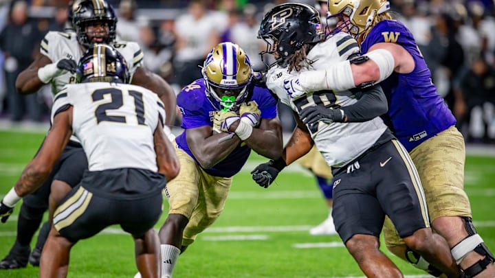 The UW's Adam Mohammed hits the hole while freshman tackle John Mills gives him a helping hand. 