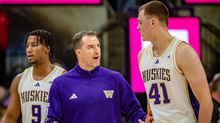 Danny Sprinkle has a sideline conversation with UW forward Jacob Ognacevic.