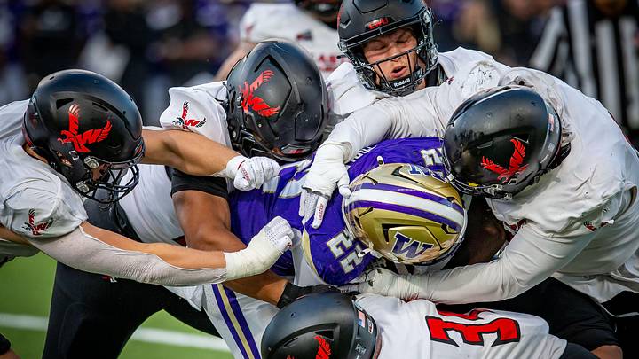 Eastern Washington players gang tackle UW running back Trey Cooley. Eastern Washington players gang tackle UW running back Trey Cooley.