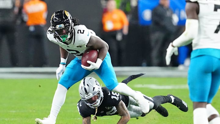 Dec 22, 2024; Paradise, Nevada, USA; Jacksonville Jaguars running back D'Ernest Johnson (2) breaks the tackle of Las Vegas Raiders cornerback Jack Jones (18) during the fourth quarter at Allegiant Stadium. Mandatory Credit: Stephen R. Sylvanie-Imagn Images