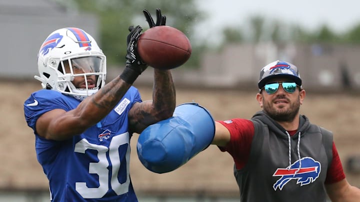 Bills cornerback Dane Jackson (30) eyes in the ball as he is hit by linebackers coach Bobby Babich