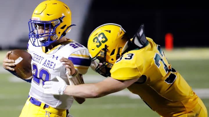 Derry quarterback Anthony Sacco, left, attempts to avoid Deer Lakes linebacker Daniel Bichler Friday night at Deer Lakes High School. The Trojans rallied late to beat the Lancers, 24-21.