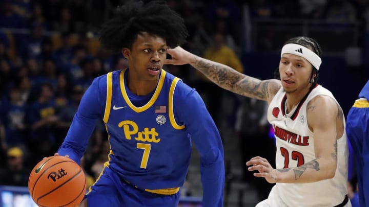 Feb 17, 2024; Pittsburgh, Pennsylvania, USA;  Pittsburgh Panthers guard Carlton Carrington (7) drives to the basket against Louisville Cardinals guard Tre White (22) during the first half at the Petersen Events Center. Mandatory Credit: Charles LeClaire-USA TODAY Sports