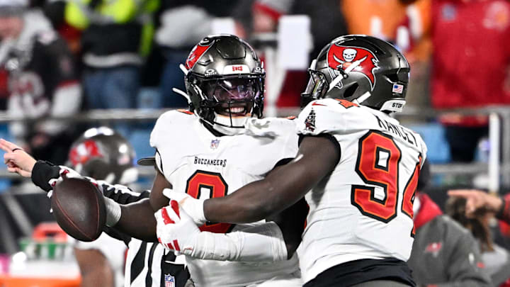 Dec 1, 2024; Charlotte, North Carolina, USA; Tampa Bay Buccaneers linebacker Yaya Diaby (0) celebrates with defensive tackle Calijah Kancey (94) after recovering a fumble in overtime in overtime at Bank of America Stadium. Mandatory Credit: Bob Donnan-Imagn Images