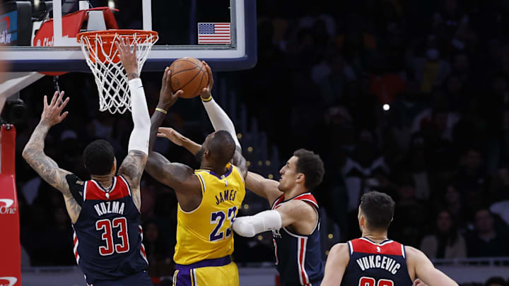 Apr 3, 2024; Washington, District of Columbia, USA; Los Angeles Lakers forward LeBron James (23) shoots the ball as Washington Wizards forward Kyle Kuzma (33) and Wizards forward Patrick Baldwin Jr. (7) defend in the second half at Capital One Arena. Mandatory Credit: Geoff Burke-Imagn Images