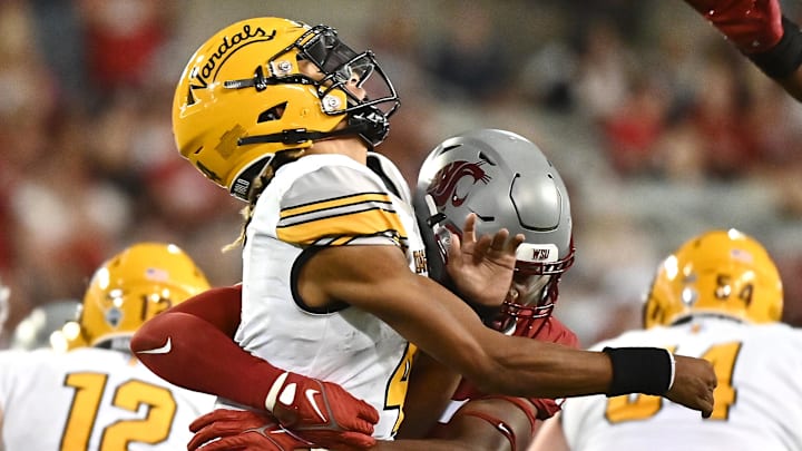 Sep 3, 2022; Pullman, Washington, USA; Idaho Vandals quarterback Gevani McCoy (4) is hit by Washington State Cougars defensive end Raam Stevenson (45) after throwing the ball in the second half at Gesa Field at Martin Stadium. Washington State won 24-17. Mandatory Credit: James Snook-Imagn Images