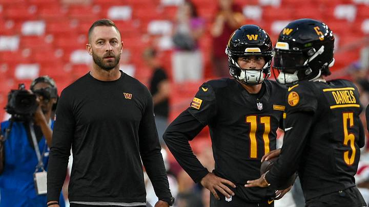 Aug 25, 2024; Landover, Maryland, USA; Washington Commanders offensive coordinator Kliff Kingsbury watches Washington Commanders quarterback Jayden Daniels (5) warm up before the game against the New England Patriots  at Commanders Field. Mandatory Credit: Tommy Gilligan-USA TODAY Sports