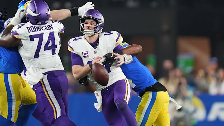 Minnesota Vikings quarterback Sam Darnold (14) fumbles the ball while being sacked by Los Angeles Rams cornerback Ahkello Witherspoon (4) during their playoff game at State Farm Stadium on Jan. 13, 2025, in Glendale.