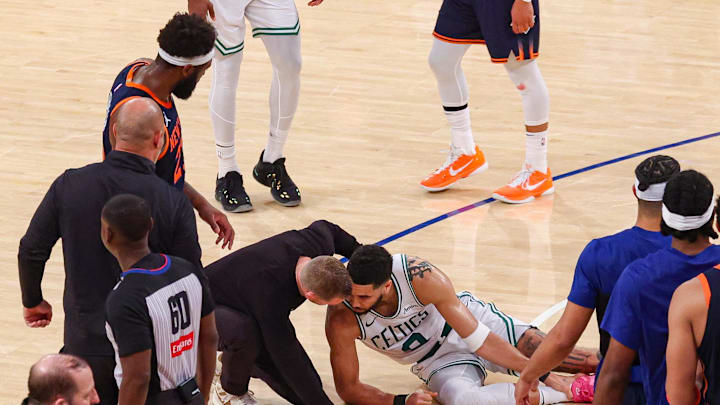 May 12, 2025; New York, New York, USA; Boston Celtics forward Jayson Tatum (0) with a member of the medical staff on the court after an injury in the second half during game four of the second round for the 2025 NBA Playoffs against the New York Knicks at Madison Square Garden. Tatum would leave the game with an injury after this play. Mandatory Credit: Vincent Carchietta-Imagn Images