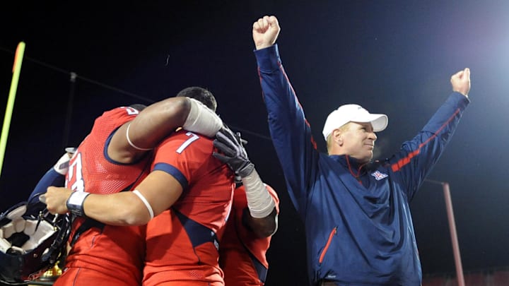 Dec 20, 2008; Las Vegas, NV, USA; Arizona Wildcats coach Mike Stoops (right) celebrates as players Ronnie Palmer (33), Willie Tuitama (7) and Devin Ross (6) embrace after the Wildcats' 31-21 victory over the Brigham Young Cougars in the Las Vegas Bowl at Sam Boyd Stadium. Mandatory Credit: Kirby Lee/Image of Sport-Imagn Images Dec 20, 2008; Las Vegas, NV, USA; Arizona Wildcats coach Mike Stoops (right) celebrates as players Ronnie Palmer (33), Willie Tuitama (7) and Devin Ross (6) embrace after the Wildcats' 31-21 victory over the Brigham Young Cougars in the Las Vegas Bowl at Sam Boyd Stadium. Mandatory Credit: Kirby Lee/Image of Sport-Imagn Images
