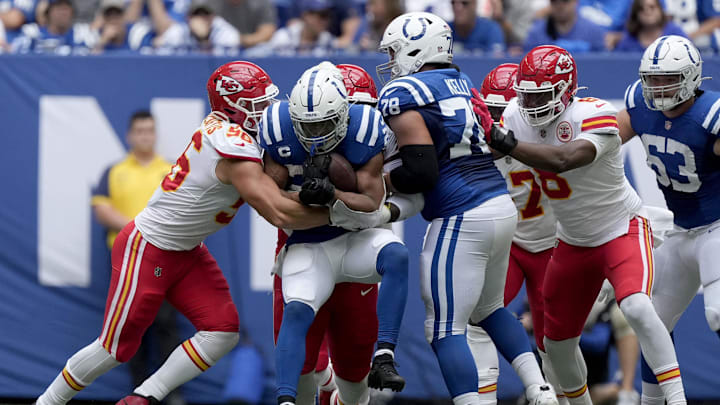 Sep 25, 2022; Indianapolis, Indiana, USA; Kansas City Chiefs defensive end George Karlaftis (56) wraps up Indianapolis Colts running back Jonathan Taylor (28) as he rushes the ball during the game at Lucas Oil Stadium. Mandatory Credit: Robert Scheer/IndyStar Staff-Imagn Images