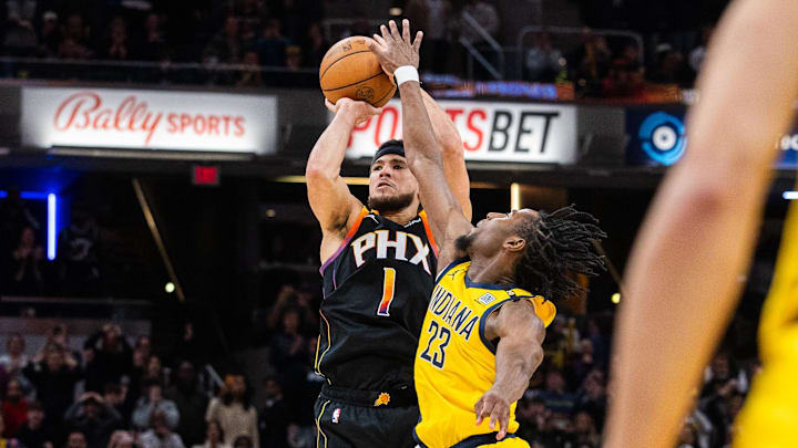 Jan 26, 2024; Indianapolis, Indiana, USA; Phoenix Suns guard Devin Booker (1) shoots the ball as time expires with Indiana Pacers forward Aaron Nesmith (23) defending  in the second half at Gainbridge Fieldhouse. Mandatory Credit: Trevor Ruszkowski-Imagn Images