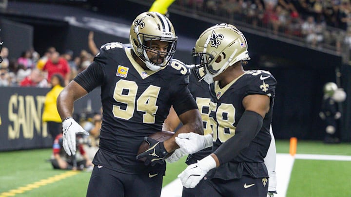 Oct 13, 2024; New Orleans, Louisiana, USA;  New Orleans Saints defensive end Cameron Jordan (94) reacts to intercepting the pass of Tampa Bay Buccaneers quarterback Baker Mayfield (6) during the first half at Caesars Superdome. Mandatory Credit: Stephen Lew-Imagn Images