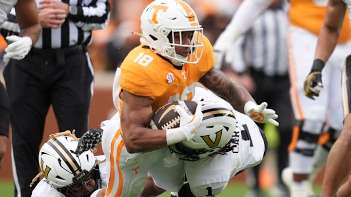 Tennessee running back DeSean Bishop (18) is brought down by Vanderbilt safety CJ Heard (8) and Vanderbilt safety Dontae Carter (1) during an NCAA college football game on Nov. 29, 2025, in Knoxville, Tennessee.