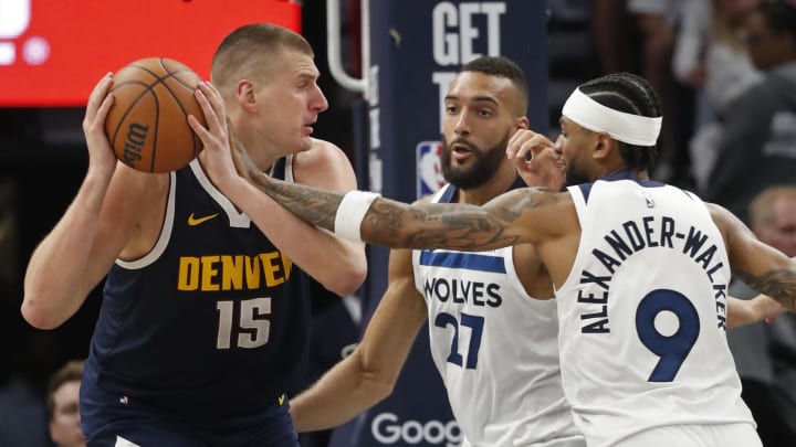 May 12, 2024; Minneapolis, Minnesota, USA; Denver Nuggets center Nikola Jokic (15) works around Minnesota Timberwolves center Rudy Gobert (27) and guard Nickeil Alexander-Walker (9) in the third quarter of game four of the second round for the 2024 NBA playoffs at Target Center. Mandatory Credit: Bruce Kluckhohn-USA TODAY Sports