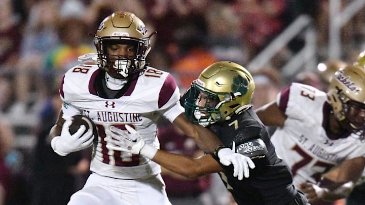 St. Augustine's Somourian Wingo (18) tries to get away from Nease Panthers Adriann Reyes (7) on a late second quarter run. The St. Augustine Yellow Jackets traveled to Nease High School's Panther Stadium for Friday night's Saint Johns County high school football rivalry game October 6, 2023.