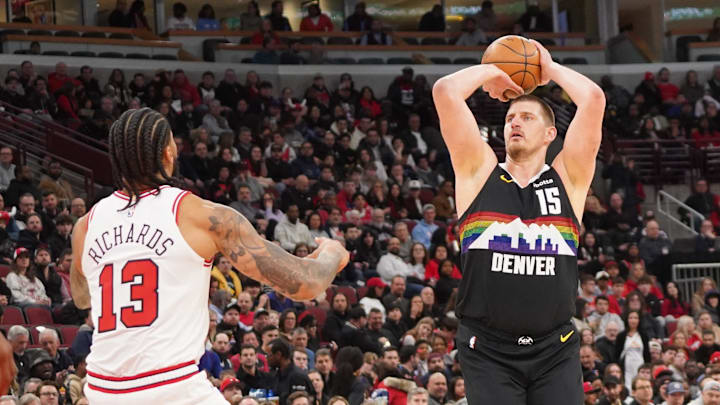 Feb 7, 2026; Chicago, Illinois, USA; Denver Nuggets center Nikola Jokic (15) makes a three point basket over Chicago Bulls center Nick Richards (13) during the first half at United Center. Mandatory Credit: David Banks-Imagn Images