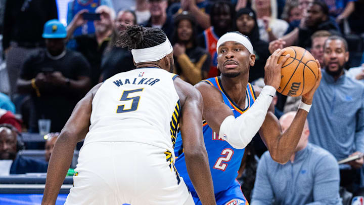 Oct 23, 2025; Indianapolis, Indiana, USA;  Oklahoma City Thunder guard Shai Gilgeous-Alexander (2) holds the ball while Indiana Pacers forward Jarace Walker (5) defends in the second half at Gainbridge Fieldhouse. Mandatory Credit: Trevor Ruszkowski-Imagn Images