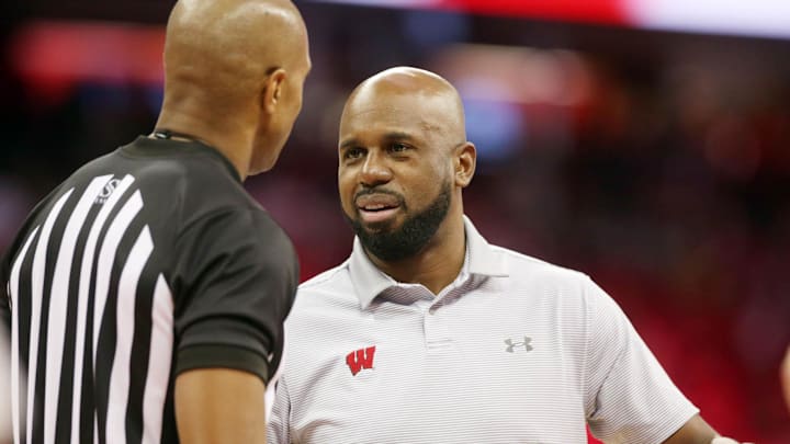Feb 12, 2022; Madison, Wisconsin, USA;  Wisconsin Badgers assistant coach Sharif Chambliss talks with NCAA referee Steve McJunkins before the game with the Rutgers Scarlet Knights at the Kohl Center.