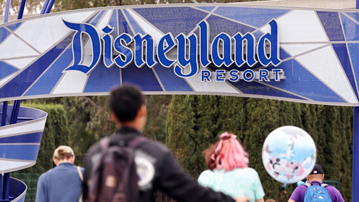 ANAHEIM, CALIFORNIA – APRIL 24: People walk toward an entrance to Disneyland on April 24, 2023 in Anaheim, California. Disney will lay off several tho