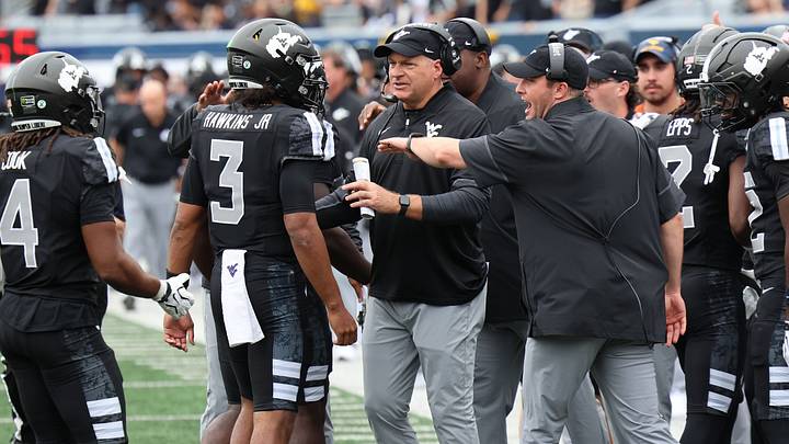 West Virginia University head coach Rich Rodriguez greets quarterback Mike Hawkins Jr. (3) West Virginia University head coach Rich Rodriguez greets quarterback Mike Hawkins Jr. (3)
