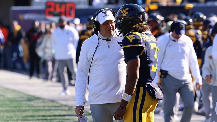 West Virginia University head coach Rich Rodriguez chats with quarterback Mike Hawkins Jr West Virginia University head coach Rich Rodriguez chats with quarterback Mike Hawkins Jr