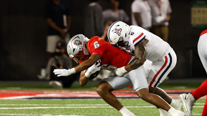 Aug 31, 2024; Tucson, Arizona, USA; New Mexico Lobos running back Eli Sanders (6) get tackled by Arizona Wildcats linebacker Jacob Manu (5) during first quarter at Arizona Stadium. Mandatory Credit: Aryanna Frank-USA TODAY Sports