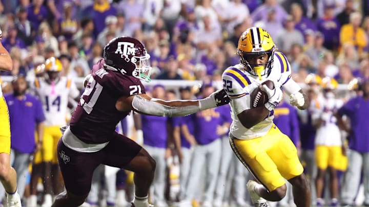 Oct 25, 2025; Baton Rouge, Louisiana, USA; Louisiana State Tigers running back Harlem Berry (22) runs against Texas A&M Aggies linebacker Taurean York (21) during the first half at Tiger Stadium. Mandatory Credit: Stephen Lew-Imagn Images