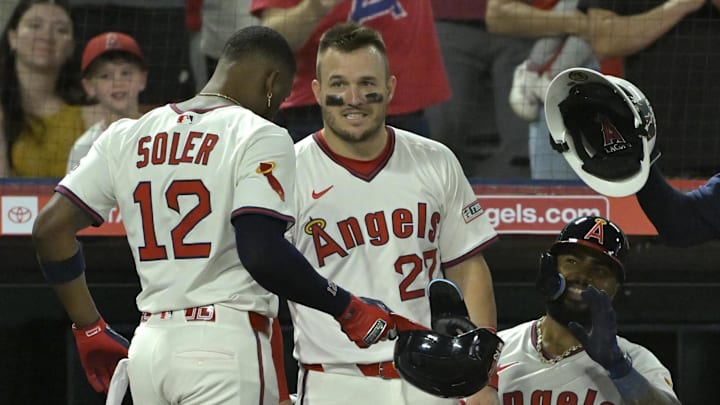 Jul 9, 2025; Anaheim, California, USA;  Los Angeles Angels right fielder Jorge Soler (12) is congratulated by designated hitter Mike trout (27) and second baseman Luis Rengifo (2) after hitting a two-run home run in the eighth inning against the Texas Rangers at Angel Stadium. Mandatory Credit: Jayne Kamin-Oncea-Imagn Images