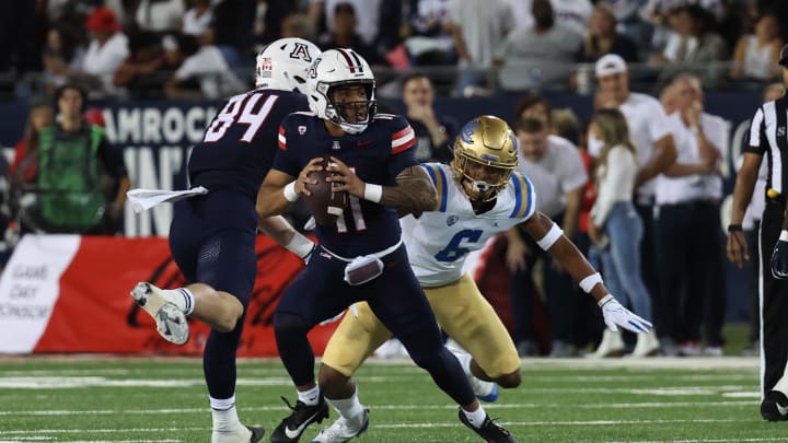Nov 4, 2023; Tucson, Arizona, USA; Arizona Wildcats quarterback Noah Fifita #11 makes a pass under pressure against UCLA Bruins quarterback Justyn Martin #6 during the first half at Arizona Stadium. 