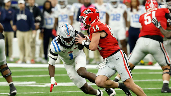 Jan 1, 2026; New Orleans, LA, USA; Georgia Bulldogs quarterback Gunner Stockton (14) scrambles with the ball under pressure from Mississippi Rebels linebacker Princewill Umanmielen (1) in the third quarter during the 2026 Sugar Bowl and quarterfinal game of the College Football Playoff at Caesars Superdome. Mandatory Credit: Geoff Burke-Imagn Images