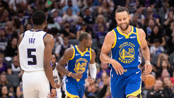 Golden State Warriors guard Stephen Curry (30) laughs with Sacramento Kings guard De'Aaron Fox (5) after scoring during the second quarter at Golden 1 Center. Mandatory Credit: Ed Szczepanski-Imagn Images