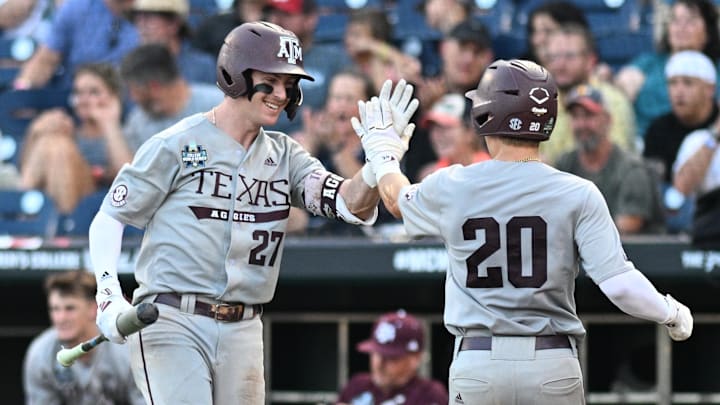 Jun 17, 2024; Omaha, NE, USA;  Texas A&M Aggies first baseman Ted Burton (27) greets catcher Jackson Appel (20) after scoring against the Kentucky Wildcats during the sixth inning at Charles Schwab Field Omaha. Mandatory Credit: Steven Branscombe-Imagn Images