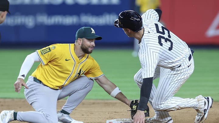 Jun 27, 2025; Bronx, New York, USA;  New York Yankees left fielder Cody Bellinger (35) beats the tag of Athletics second baseman Max Schuemann (12) for a stolen base in the eighth inning at Yankee Stadium. Mandatory Credit: Wendell Cruz-Imagn Images