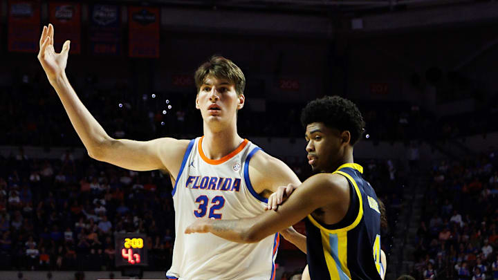 Nov 21, 2025; Gainesville, Florida, USA; Merrimack Warriors guard Tye Dorset (4) defends Florida Gators center Olivier Rioux (32) during the second half at Exactech Arena at the Stephen C. O'Connell Center. Mandatory Credit: Matt Pendleton-Imagn Images
