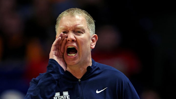 Mar 20, 2025; Lexington, KY, USA;  Utah State Aggies head coach Jerrod Calhoun calls to his team during the first half against the UCLA Bruins in the first round of the NCAA Tournament at Rupp Arena. Mandatory Credit: Aaron Doster-Imagn Images