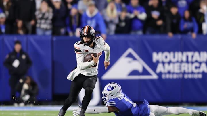 Oct 18, 2024; Provo, Utah, USA; Oklahoma State Cowboys quarterback Garret Rangel (13) runs the ball past Brigham Young Cougars safety Micah Harper (1) during the second quarter at LaVell Edwards Stadium. Mandatory Credit: Rob Gray-Imagn Images