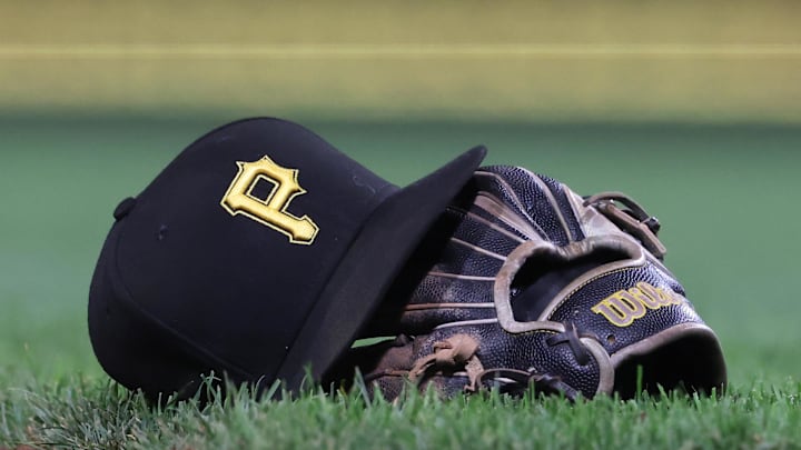 Sep 16, 2025; Pittsburgh, Pennsylvania, USA; A hat and glove belonging to Pittsburgh Pirates third baseman Jared Triolo (not pictured) on the field against the Chicago Cubs during the sixth inning at PNC Park. Mandatory Credit: Charles LeClaire-Imagn Images