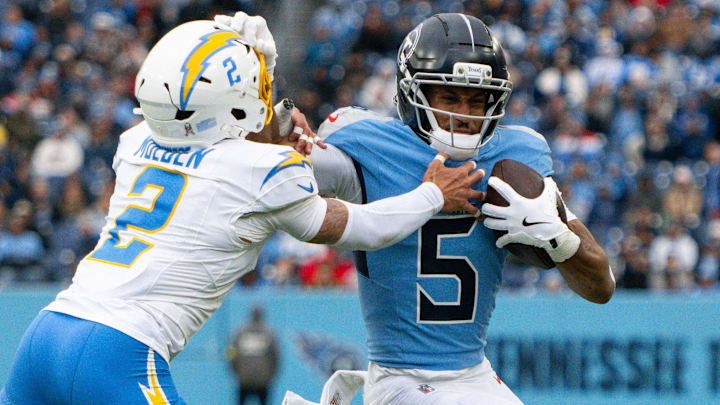 Nov 2, 2025; Nashville, Tennessee, USA; Tennessee Titans wide receiver Elic Ayomanor (5) stiff arms Los Angeles Chargers cornerback Elijah Molden (2)  during the first half at Nissan Stadium. Mandatory Credit: Steve Roberts-Imagn Images