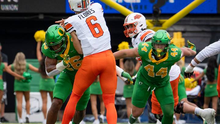 Oregon inside linebacker Devon Jackson, left, and outside linebacker Teitum Tuioti, right, pressure Oklahoma State quarterback Zane Flores as the Oregon Ducks host the Oklahoma State Cowboys on Sept. 6, 2025, at Autzen Stadium in Eugene, Oregon.